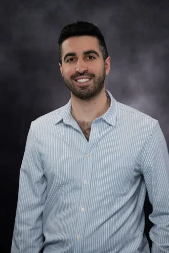 Dr. Daniel Kohanghadosh, pediatric dentist in California smiling in white coat